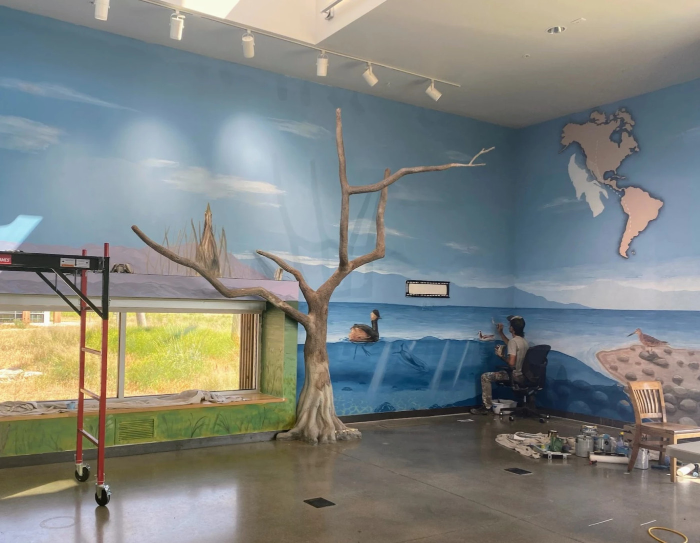 Ashley Kijowski / UDWR Franco "Vato" Cervato paints the Great Salt Lake mural at the Eccles Wildlife Education Center in Farmington Bay.